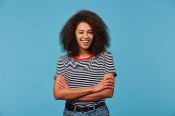 Young african american woman over blue wall wearing stripped t-shirt smiling with happy face...