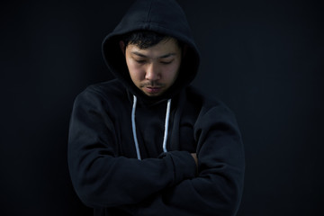 Naklejka na ściany i meble Asian hacker in black hood on black background,Hack password,hacking safety systems to steal information