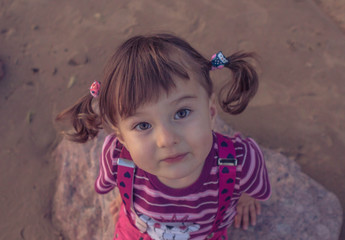 A little girl walks on the beach during sunset.