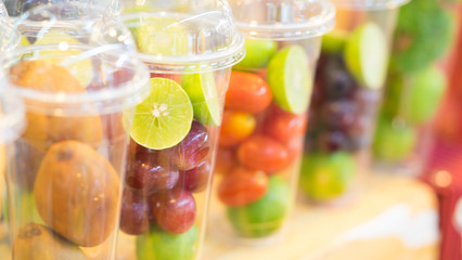 Fresh mix fruit shake cut into small pieces in a disposable glass