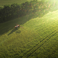 Agricultural machinery in the field. Tractor with a sprayer. Aerial view