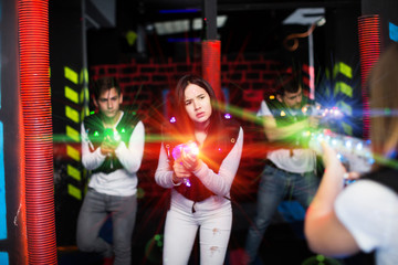 Girl playing laser tag in colorful beams