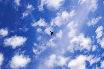 Airplane flying on a cloudy sky background