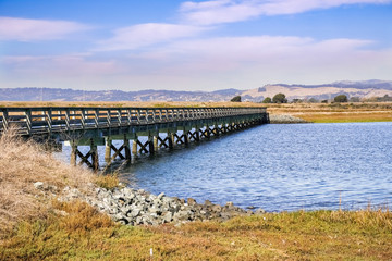Fototapeta na wymiar Bridge over the marshes of East San Francisco Bay, Hayward, California