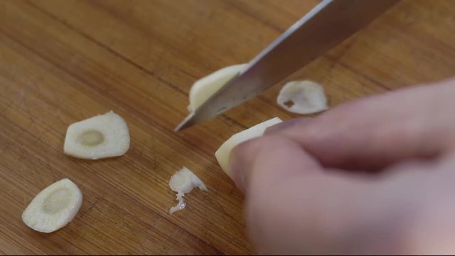 cutting garlic on a wooden Board close-up cooking at home