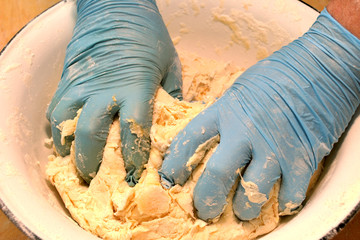 Male hands kneading fresh dough on the kitchen table. Close up