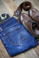 brown boots, blue jeans, leather belt and rangefinder camera