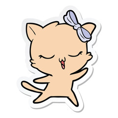 sticker of a cartoon dancing cat with bow on head