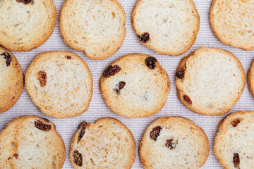 Mini round toasts of bread with raisins. Background. On delicate fabric background.