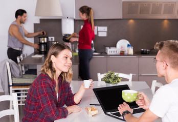 Girl discussing with guy in kitchen of hostel