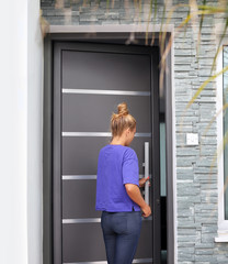 Beautiful woman opening the door of her home.Woman entering the house