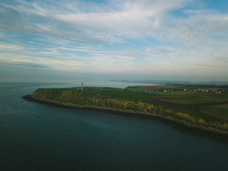 Fototapeta premium green plain with a view of the lighthouse.