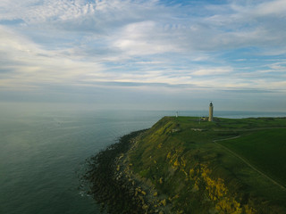 green plain with a view of the lighthouse.