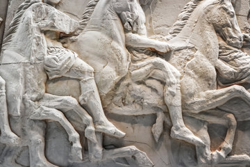 Background of horses in battle - cracked and mended white marble ancient bas relief sculptures from Greece