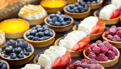 Biscuit cake with cream. Cake with berries: raspberries, blueberries, strawberries.