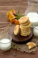 Homemade cookies and cups of milk on wood