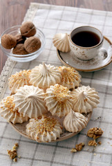 Fototapeta na wymiar meringues with nuts and cup of coffee