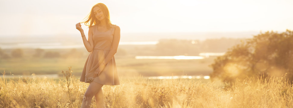 Dreamy Girl In A Field At Sunset, A Young Woman In A Haze From The Sun Enjoying Nature, Romantic Style