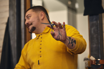 Stylish barber man with hairdressing tools in his hands prepare for work