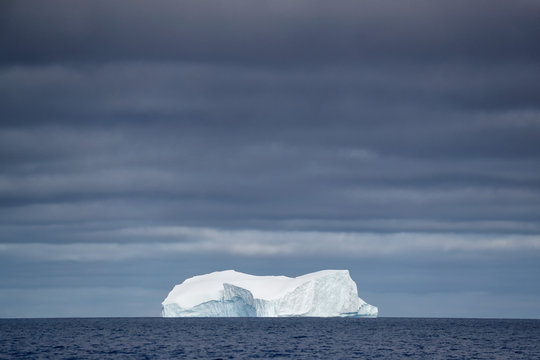 Iceberg under darkening sky