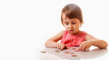 Cute little girl saving money coins. Business and financial education concept.
