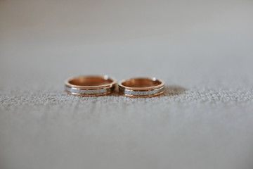 Close up view of stylish gold wedding rings on the textile