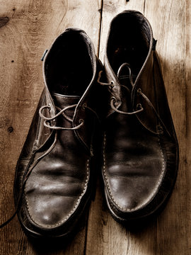 Unlaced men's boots on wood floor