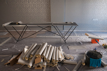 rolls of cropped Wallpaper in a pile and a table for cutting Wallpaper