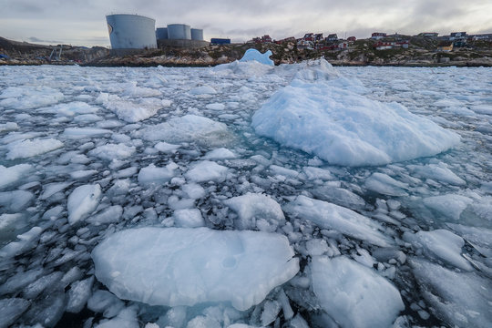 Ice floes with storage tanks in the distance