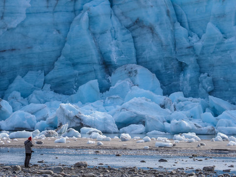 Person stands in front of melting glacier