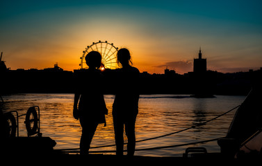 silhouettes of two young girls at sunset