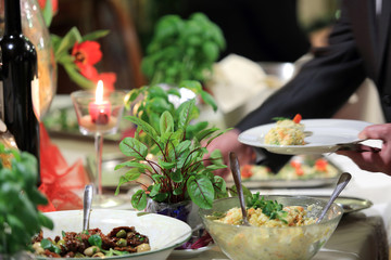 Fototapeta na wymiar Talerz z jedzeniem w dłoniach mężczyzny na szwedzkim stole w restauracji.
