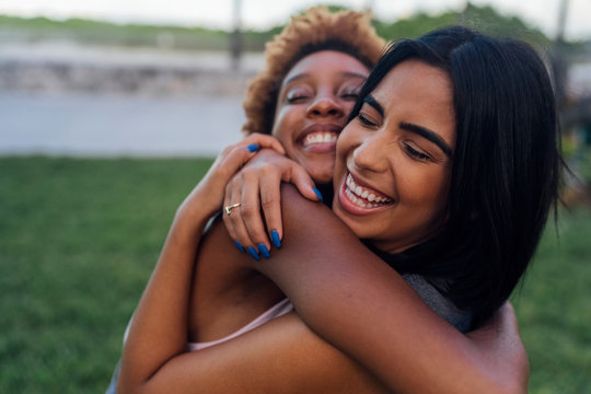 Portrait of two happy female friends hugging in a park