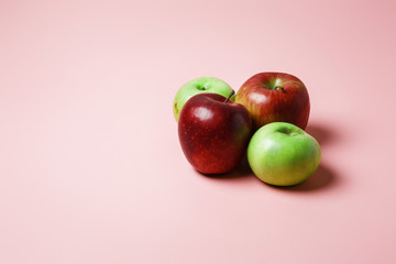 Beautiful ripe juicy red and green apples from their own garden on a pink background. Good snack at night and snack after sport