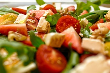 Fresh and healthy salad with fruits, vegetable, rocket and nuts