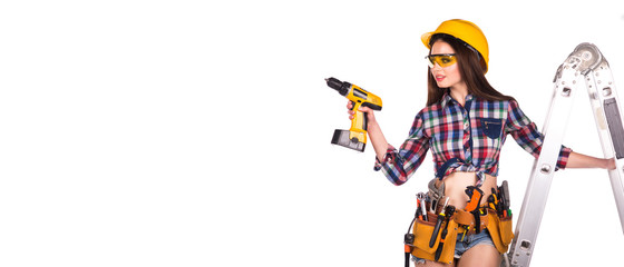Beautiful girl builder holding a drill in his hands. place for inscription