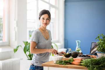 Woman preparing healthy food in her kitchen