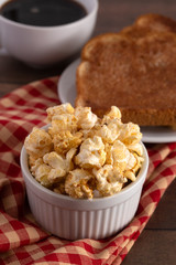 Bowl of Cinnamon Toast Flavored Popcorn on a Wooden Table