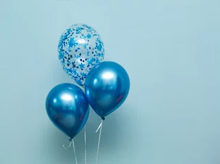 Rolgordijnen bright matte balloons on a blue background.  three blue inflated balloons. stylish party with balloons. round blue and transparent  balloon. place of celebration © mihail_pustovit