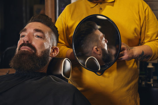 Client With Big Black Beard During Beard Shaving In Barber Shop