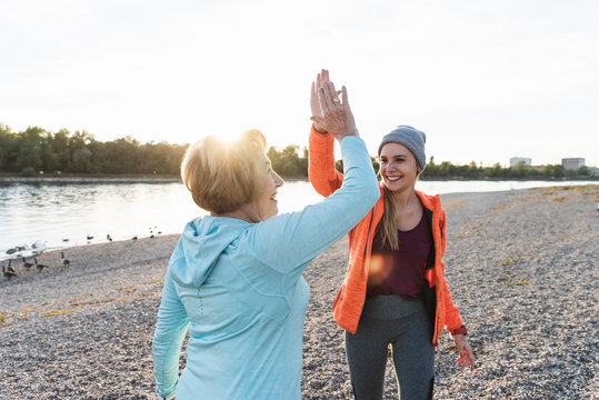 Grandmother and granddaughter high-fiving after training at the river