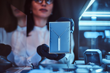 Woman assistant shows the exclusive gold necklace in the luxury jewelry store