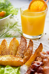 Breakfast with bacon. Morning breakfast with delicious fried bacon. French fries and tender egg, close-up.