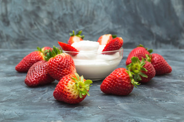 Fresh strawberries with whipped cream on dark background