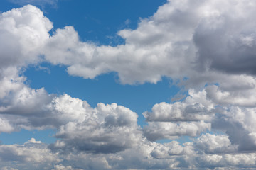 Blue sky with white soft clouds in the rays of sunlight.