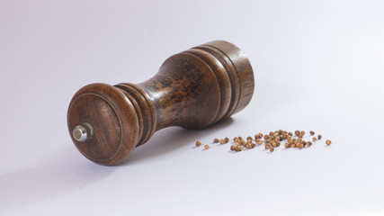 Upper view of a lying wooden pepper shaker with white background