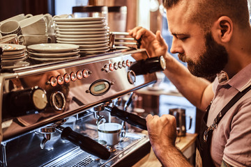Close-up photo of a stylish barista working on a coffee machine in a coffee shop or restaurant