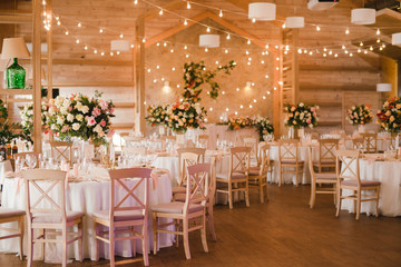 Coziness and style. Modern event design. Table setting at wedding reception. Floral compositions...