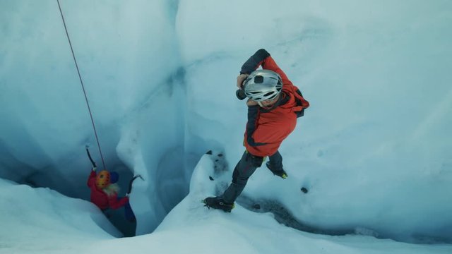 High angle view of photographer photographing ice climber using hooks on glacier / Palmer, Alaska, United States