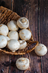champignonsFresh mushrooms in a basket on a wooden background.